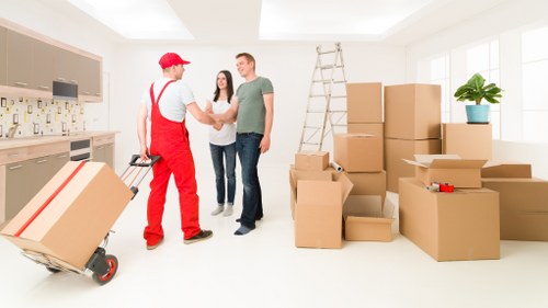 Loading sofas, tables, and other furniture into a removals van in New Malden