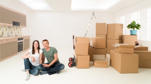 Local removals team handling boxes and furniture near New Malden