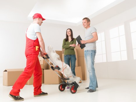 Removal team handling furniture in a New Malden family home move
