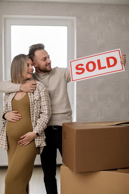 Two professional movers from Man and Van New Malden in a bright, spacious room with white walls and large arched windows, are shown during a home relocation process. One mover, with a beard and curly 